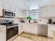 Well-lit kitchen with stainless steel appliances, white cabinets, and modern countertops at 13908 E Linvale Pl, Aurora, CO 80014
