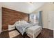 Inviting bedroom with a wood accent wall, hardwood floors, and soft natural light at 14204 E Baltic Cir, Aurora, CO 80014