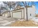 Townhouse exterior featuring a two-car garage and mature trees at 14204 E Baltic Cir, Aurora, CO 80014