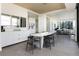 Modern dining area with white table and gray chairs, offering an open concept to the living room at 1750 Wewatta St # 1940, Denver, CO 80202