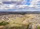 Expansive aerial view of a residential community with open green spaces, parks, and housing under a bright, cloudy sky at 5934 Kingsfield St, Castle Rock, CO 80104