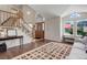 Spacious foyer features a wooden front door, staircase, and seating area, filled with natural light at 9537 Chesapeake St, Highlands Ranch, CO 80126