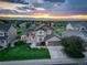 Beautiful home exterior with a manicured lawn, mature trees, and stunning sunset views in the background at 9537 Chesapeake St, Highlands Ranch, CO 80126