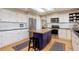 Modern kitchen features white cabinets, stainless steel appliances, and a center island with a butcher block top at 9537 Chesapeake St, Highlands Ranch, CO 80126