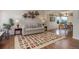 Inviting living room featuring hardwood floors, stylish rug, comfortable sofa, and decorative shelving at 9537 Chesapeake St, Highlands Ranch, CO 80126