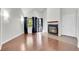 Open living room with wood floors, a fireplace, and large windows with curtains at 980 S Dahlia St # F, Denver, CO 80246