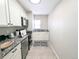 Galley kitchen featuring white cabinets, granite countertops, and stainless steel appliances at 1164 Wabash St, Denver, CO 80220