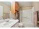 Bright bathroom featuring a white vanity with a sink, toilet, and bathtub with white tiles and shower at 5786 Biscay St, Denver, CO 80249
