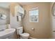 A half bathroom shows a pedestal sink and a toilet, with a medicine cabinet and a window at 5786 Biscay St, Denver, CO 80249