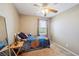 This cozy bedroom has a ceiling fan, a bright flower quilt, and a window with blinds and curtains at 5786 Biscay St, Denver, CO 80249