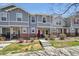 Charming townhome featuring a red front door, brick accents, and well-maintained landscaping at 5786 Biscay St, Denver, CO 80249