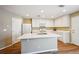 Bright kitchen featuring an island with seating, white cabinets, and stainless steel appliances at 5786 Biscay St, Denver, CO 80249