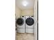 A compact laundry room features a modern washer and dryer, with storage shelves, and a tiled floor at 5786 Biscay St, Denver, CO 80249