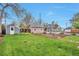 Spacious backyard featuring a lush lawn, storage shed, garden boxes, and mature trees at 3201 S Clarkson St, Englewood, CO 80113
