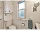 Well-lit bathroom with a white toilet, built in cabinet, and a window providing natural light at 3201 S Clarkson St, Englewood, CO 80113