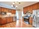 Well-maintained kitchen featuring stainless steel appliances, wooden cabinets, hardwood floors and vintage light fixture at 3201 S Clarkson St, Englewood, CO 80113