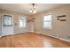 Bright living room featuring hardwood floors, white trim, floating shelves, and natural light from two windows at 3201 S Clarkson St, Englewood, CO 80113