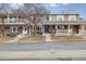 Charming townhome with a brick exterior, a covered front porch, and well-maintained landscaping at 7272 E Appleton Cir, Centennial, CO 80112