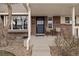 Inviting front porch with a seating area, brick accents, and a well-maintained exterior at 7272 E Appleton Cir, Centennial, CO 80112