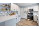 Updated kitchen with stainless steel appliances, white cabinetry, and attractive tile backsplash at 7272 E Appleton Cir, Centennial, CO 80112