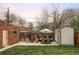 Backyard featuring a patio set with a dining table, chairs, shed and well-maintained lawn at 1055 S Clayton Way, Denver, CO 80209