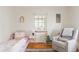 Bright bedroom featuring a light pink bed frame, striped rug, and comfortable glider at 1055 S Clayton Way, Denver, CO 80209