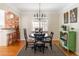 Cozy dining area featuring a round table, elegant chandelier, and a view into the adjacent kitchen space at 1055 S Clayton Way, Denver, CO 80209