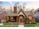 Charming brick home with a cozy front porch, lush lawn, and blooming trees, creating a welcoming curb appeal at 1055 S Clayton Way, Denver, CO 80209