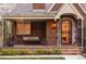 Charming brick home with a covered porch and swing, with manicured landscaping adding curb appeal at 1055 S Clayton Way, Denver, CO 80209