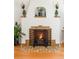 Close-up of a charming fireplace with decorative tile surround, wooden mantel shelves, and a protective metal screen at 1055 S Clayton Way, Denver, CO 80209