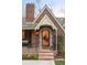 Inviting front entrance with stone steps, wrought iron railing, and a decorative door, framed by lush greenery at 1055 S Clayton Way, Denver, CO 80209