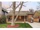 Charming brick home with a well-manicured lawn and mature tree offering shade and curb appeal at 1055 S Clayton Way, Denver, CO 80209