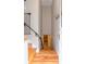 Hallway leading to a room with a crib, featuring hardwood floors and a staircase at 1055 S Clayton Way, Denver, CO 80209