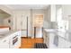 Bright and spacious kitchen with white cabinets, marble countertops, stainless steel appliances, and hardwood floors at 1055 S Clayton Way, Denver, CO 80209