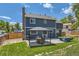 Rear exterior view of the home with a well-maintained lawn, patio, and outdoor seating at 9929 W Fairview Ave, Littleton, CO 80127