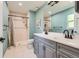 Bright bathroom featuring double sink vanity, tiled shower, and updated fixtures at 9929 W Fairview Ave, Littleton, CO 80127