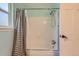 Clean bathroom featuring a shower-tub combo and a gray striped shower curtain at 9929 W Fairview Ave, Littleton, CO 80127