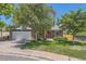 Traditional brick home with a two-car garage and manicured lawn features a bright red front door at 9929 W Fairview Ave, Littleton, CO 80127