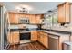 Efficient kitchen offers stainless steel appliances, wood cabinetry, and ample counter space for cooking at 9929 W Fairview Ave, Littleton, CO 80127