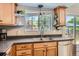 Kitchen sink area featuring wood cabinets, stainless steel appliances, and natural light from the window at 9929 W Fairview Ave, Littleton, CO 80127