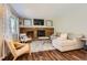 Relaxing living room boasts a brick fireplace, wooden floors, contemporary decor, and stylish furniture at 9929 W Fairview Ave, Littleton, CO 80127