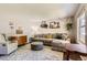 Comfortable living room features plush seating, patterned rug, and decor shelves with plants at 9929 W Fairview Ave, Littleton, CO 80127