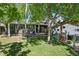 Cozy backyard features mature trees, lush lawn, a deck with pergola, and space for outdoor dining and recreation at 2865 Newland St, Wheat Ridge, CO 80214