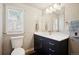 Stylish bathroom featuring a modern vanity with sleek hardware, a large mirror, and a bright window at 2865 Newland St, Wheat Ridge, CO 80214
