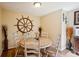 Dining room with a ship's wheel decoration and a round table illuminated by modern wall sconces at 2865 Newland St, Wheat Ridge, CO 80214