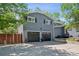 Charming two-story home with black shuttered windows, two-car garage, and a wooden fence at 2865 Newland St, Wheat Ridge, CO 80214