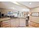 Bright, airy kitchen open to dining area with stainless steel fridge and beautiful granite countertops at 2865 Newland St, Wheat Ridge, CO 80214
