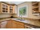 Well-lit kitchen boasts granite countertops, stainless steel appliances, and a window overlooking greenery at 2865 Newland St, Wheat Ridge, CO 80214