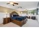Large main bedroom featuring a wooden bed frame, ceiling fans, and two sitting chairs at 2865 Newland St, Wheat Ridge, CO 80214
