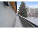 This covered balcony features a view of snow-covered roofs and large pine trees at 1437 Garfield St, Denver, CO 80206